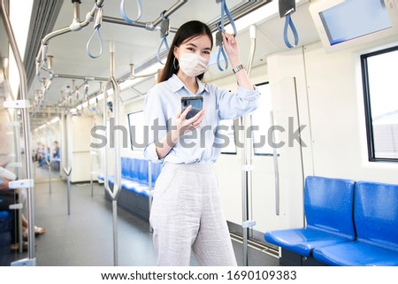 Asia working woman going to work and  
wearing hygienic mask prevent corona virus and going to work at
Sky train station