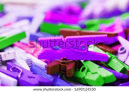 Small Clothespins of different colors close-up as a texture and background in full screen.