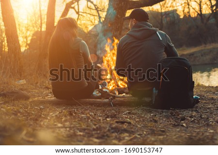man and woman by the fire in the park
