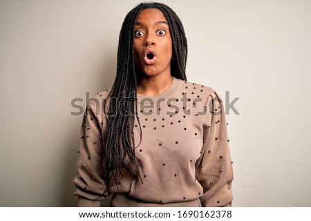 Young african american fashion woman standing casual over brown isolated background afraid and shocked with surprise expression, fear and excited face.