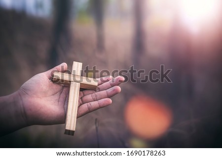 Crucifix in hands of human, Christian concept background.