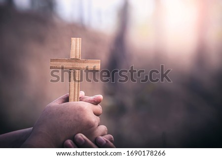 Hand holding christian Cross with sunlight, Christian concept background.