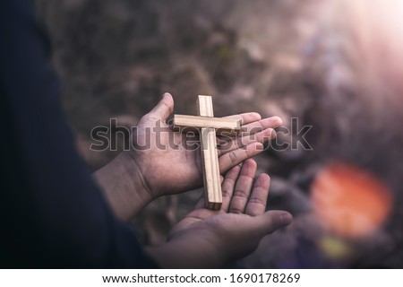 Close up christian Cross in two hands of human, Christian concept background.