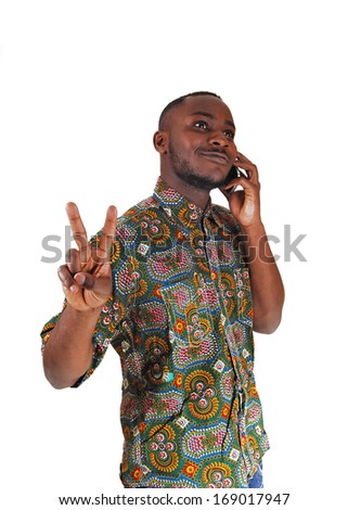 A handsome young black man in a colorful shirt talking on his cell phone for white background. 