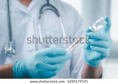 Concept fight against virus covid-19 corona virus, doctor or scientist in laboratory holding a syringe with liquid vaccines for children or older adults,Concept:diseases,medical care,science. Royalty-Free Stock Photo #1690179541