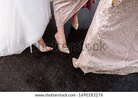 cropped photo of feet in stylish high heeled shoes. wedding day. bride with her bridesmaid. selective focus.