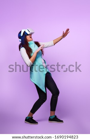 Woman wearing virtual reality headset. Concept of virtual reality, games, entertainment and communication. Image in modern neon color gamma.