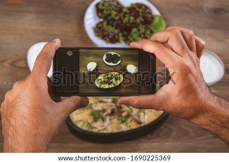 Smartphone photo of food.Mans hands make phone photography of Oriental traditional meals. lunch or dinner. For social media, blogging
