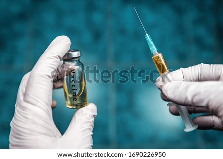 SARS-CoV-2 coronavirus vaccine and syringe in human hands