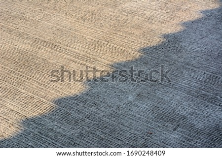 Light shadow on concrete road surface in the village.