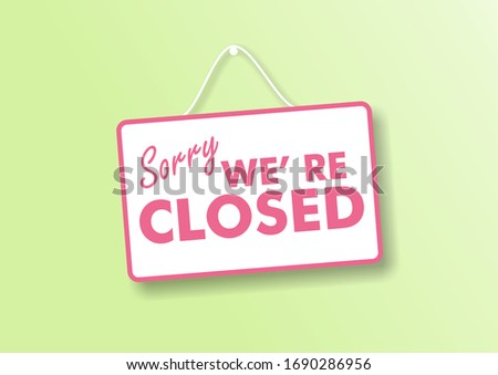 Closed business or store concept. Pink letters on white color sign board, Sorry we re closed text hanging on store green pastel wall background,