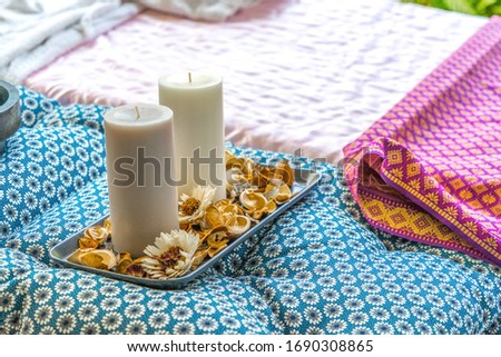 Candle with aroma flower on spa color silk  beds. Concept spa massage equipment.