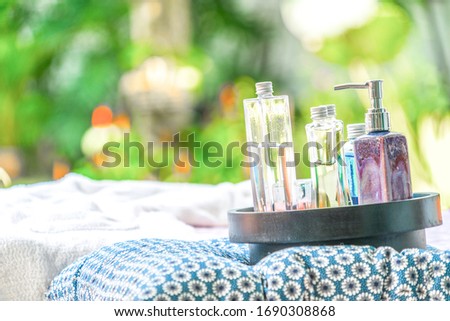 the bottle of gel and oil fragrance perfume on spa color silk beds. Concept spa massage equipment.