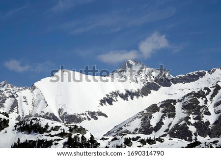 alpine landscape with snow, blue sky and sunshine in the hohe tauern national park in austria