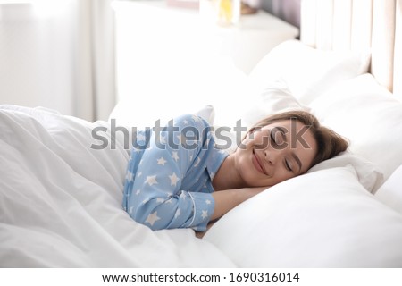 Young woman sleeping on comfortable pillow in bed at home Royalty-Free Stock Photo #1690316014