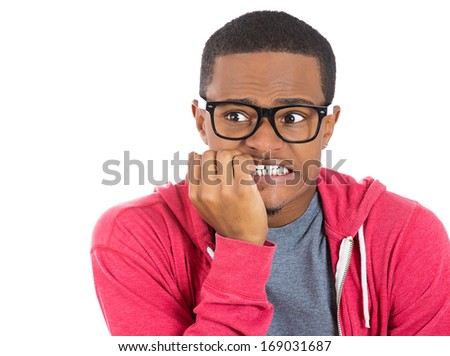 Closeup portrait of nervous, stressed young nerdy guy man in panic and fear, biting fingernails looking anxiously craving something isolated on white background. Negative emotion expression feeling