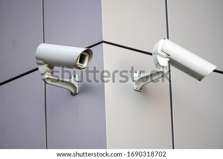 white CCTV cameras on the street, security in the city. covert shooting of what is happening. modern technologies and equipment Royalty-Free Stock Photo #1690318702