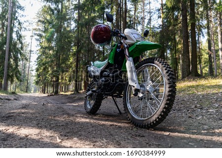 Enduro motorcycle parked in the forest, IRBIS TTR, concept, active lifestyle, enduro, off-road, the rays of the sun, background for the screen
