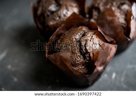 Homemade chocolate muffin on the rustic background. Selective focus.