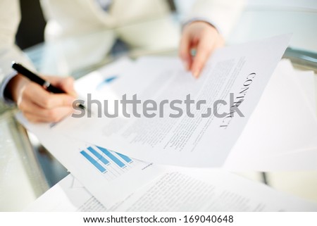 Hands of young businesswoman signing contract