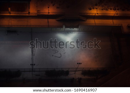 Sports ground covered with snow at night. In the center an exclamation mark