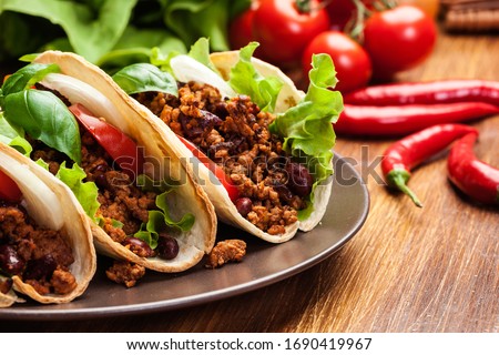 Mexican tacos with minced meat, beans and spices on a plate