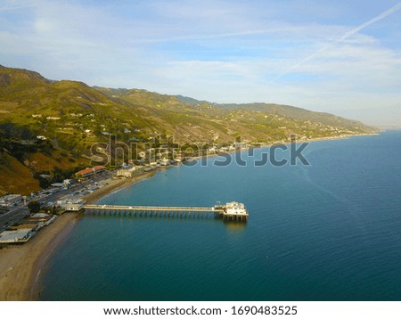 view of the coastline with blue ocean water and blue skies over the pier