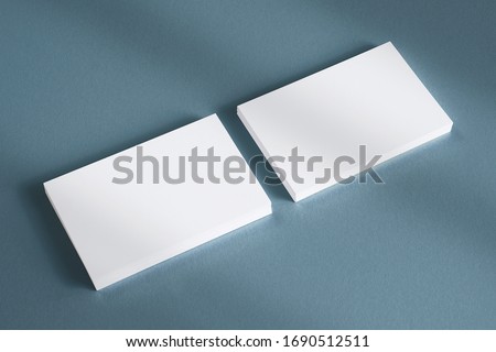 2 blank business cards stack on textured grey background and shadow overlay as template for design, logo, embossing presentation, promotion, branding etc.