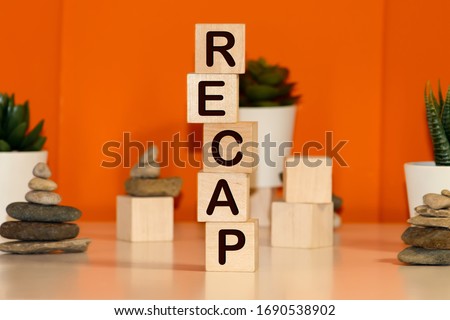Recap word from wooden blocks on desk Royalty-Free Stock Photo #1690538902