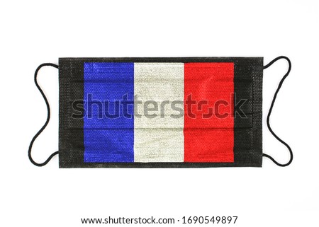 Black medical mask with picture of French Flag. Black medical mask is a symbol of mortal danger of Covid-2019 in France. Close-up protective masks textile filter, high resolution.