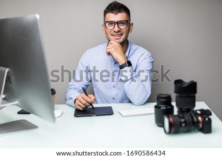 Professional photographer works in photo editing software on computer.