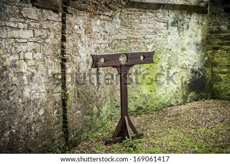 Detail of wooden medieval stocks used to incarcerate criminals in castle grounds.