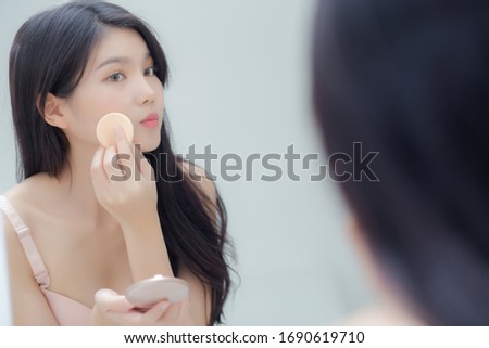 Closeup hand of young asian woman holding product cosmetic applying cream in jar, beautiful girl hand touch lotion for rejuvenation, beauty perfect, treatment and skin care and health concept.