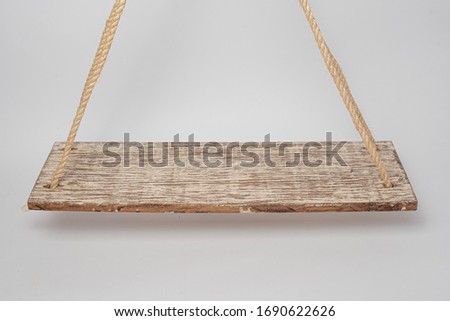 Wooden swing with hanging rope. On white background.