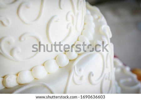 White fondant icing with decorative swirls on a wedding cake