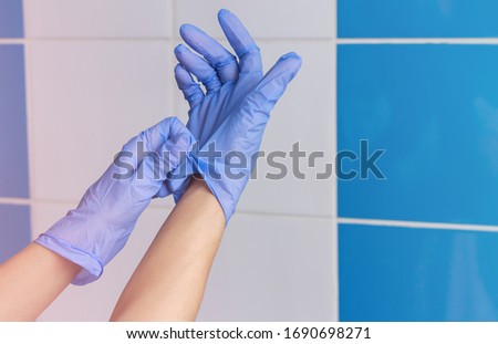 Women's hands wear rubber gloves. Infection protection. Cosmetology procedures. Doctor in gloves. Medical worker. Protected against viruses, diseases, infections. Disinfection.