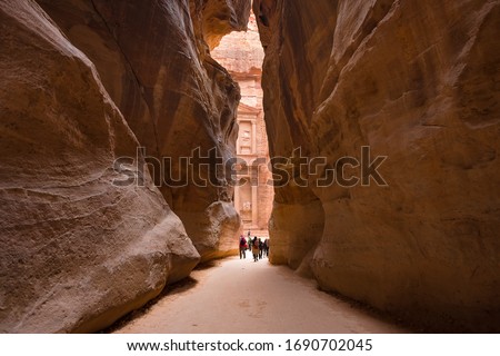 The Siq, the narrow slot-canyon path,  to the Treasury or Al Khazneh at Petra, ancient sandstone city, is a World Heritage Site. Royalty-Free Stock Photo #1690702045