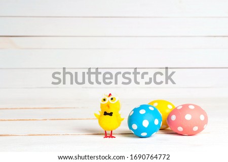 Easter eggs with decorative chick on white table. Copy space for text.