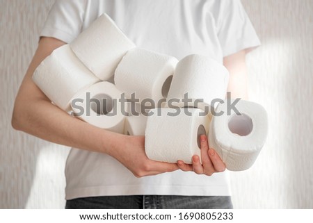 People are stocking up toilet paper for home quarantine from crownavirus. Woman holds many rolls of toilet paper. preparation for quarantine and economic crisis due to coronavirus. Hygiene concept