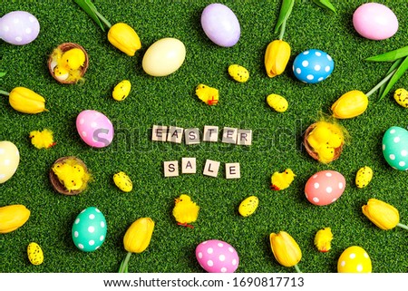Easter sale banner with colorful eggs, tulips, chickens and sale text on a green grass background. Easter background for market discount promotion. 