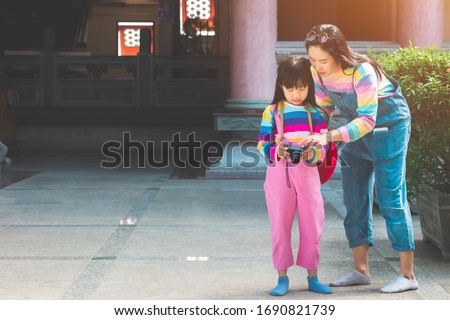 Asian child girl and mother with jumpsuit jeans and T-shirts colorful is taking pictures
