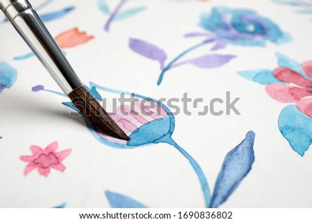 Painting flower with watercolor paint on white paper, closeup