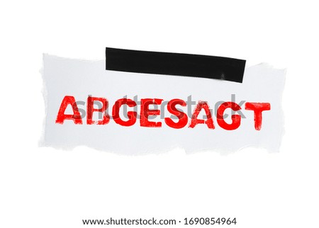 White isolated paper with black adhesive tape showing Cancelled in german language