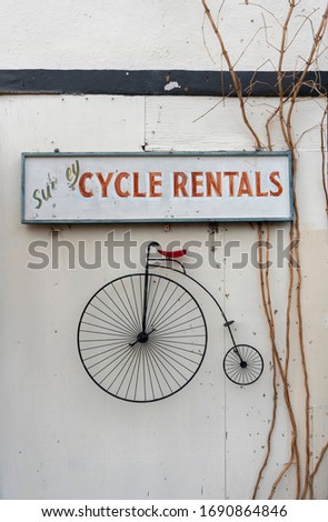 Cycle rentals sign with high wheel bicycle