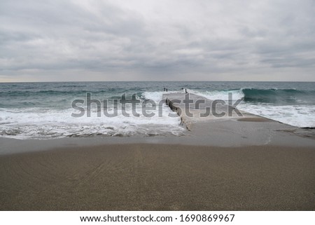 Cloudy wavy mediterranean coast and lead gray clouds