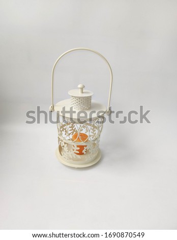 Vintage lantern with an orange candle on the white backdrop. Concept - Ramadan kareem holiday celebration. Royalty Free Stock photo