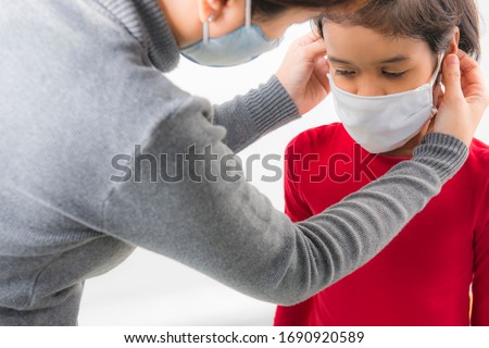 Family with kids in face mask  on white background. Mother and child wear facemask during coronavirus outbreak. Covid-19 Coronavirus concept. Virus and illness protection. Royalty-Free Stock Photo #1690920589
