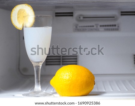Fresh lemon soda with slices of lemon in glass, freeze motion, drops Summer cold drink and cocktail