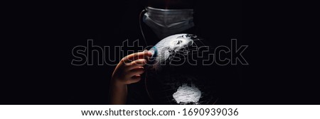 Kid hold globe put stethoscope on sphere, face covered in mask on black horizontal background. Ecological problems disasters. COVID-19 pandemic infection disease concept image, copy space for text