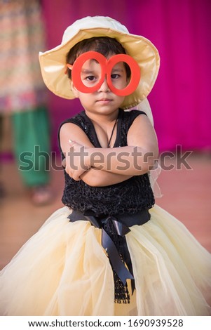 Indian Kid Wearing Big Glasses And Cap Giving angry Expression With During Party